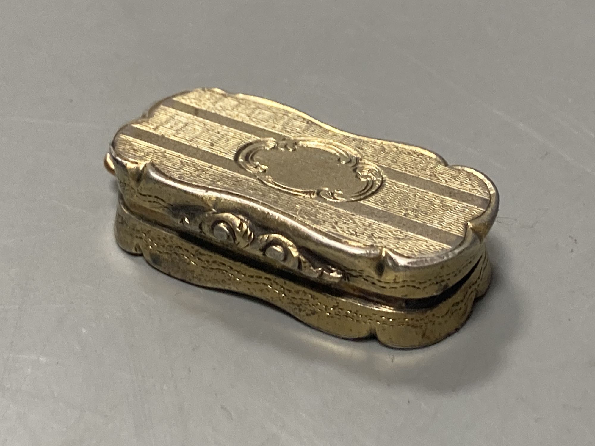 A Victorian silver gilt shaped ovoid vinaigrette, Abraham Kemp, Birmingham, 1853, 33mm.